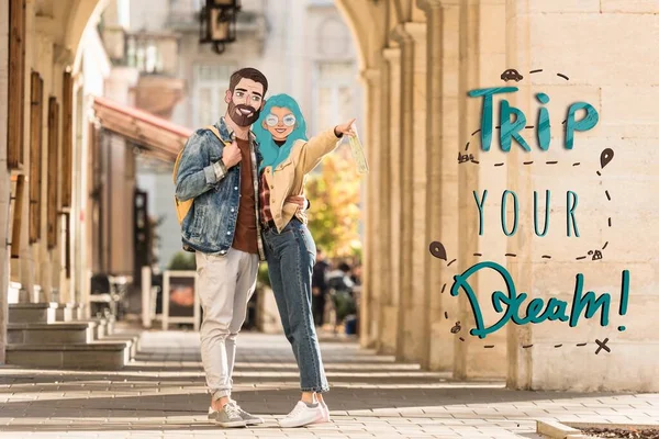 Couple of tourists with illustrated faces hugging on street and pointing with finger away, trip your dream illustration — Stock Photo