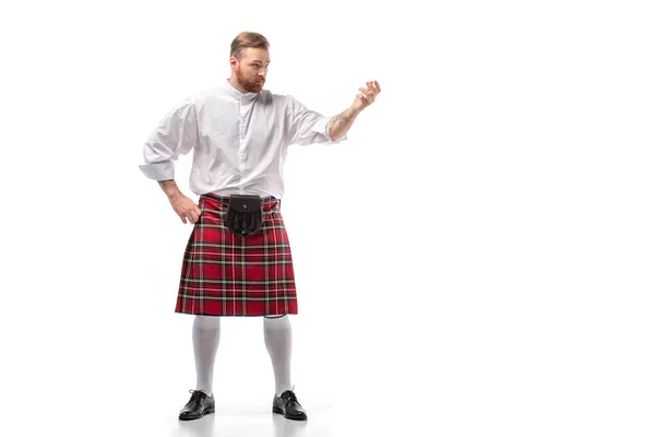 Sérieux écossais rousse homme en kilt rouge sur fond blanc — Photo de stock