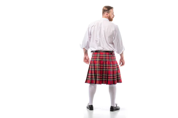 Vue arrière de l'homme rousse écossais en kilt rouge sur fond blanc — Photo de stock