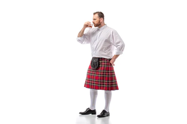 Écossais rousse homme en rouge kilt odeur whisky sur blanc — Photo de stock