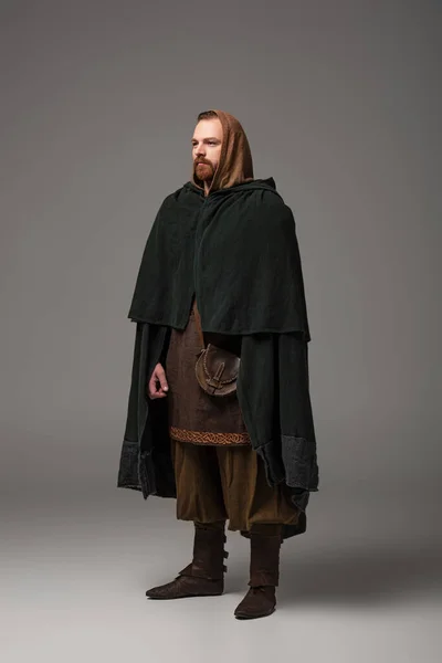 Medieval escocés pelirroja hombre en mantel sobre fondo gris - foto de stock
