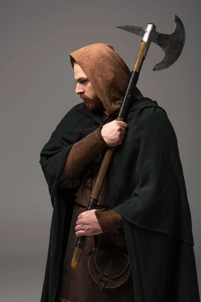 Medieval escocés pelirroja hombre en mantel con hacha de batalla sobre fondo gris - foto de stock