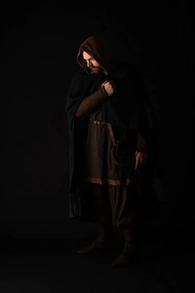 Medieval Scottish redhead man in mantel on dark isolated on black — Stock Photo