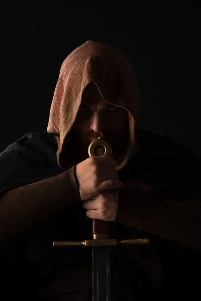 Medieval escocés hombre en mantel con espada en oscuro aislado en negro - foto de stock