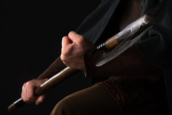 Cropped view of medieval Scottish warrior with battle axe in hands isolated on black — Stock Photo