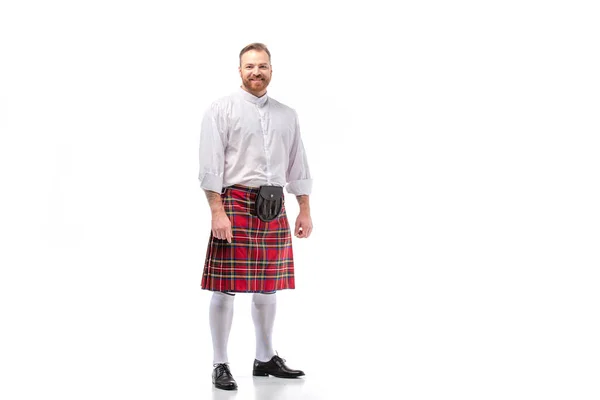 Homme barbu rousse écossais souriant en kilt de tartan rouge sur fond blanc — Photo de stock