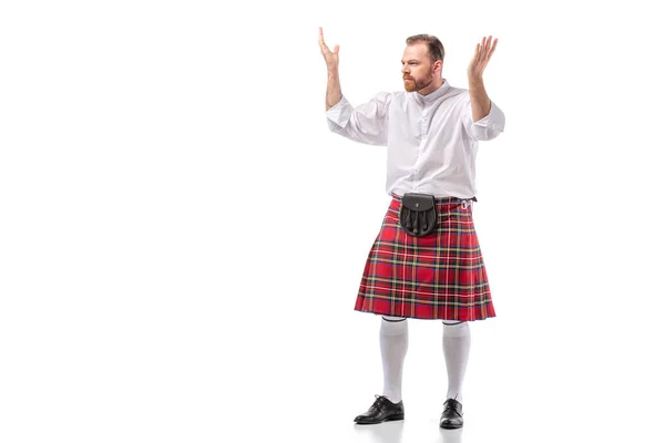 Scottish redhead bearded man in red tartan kilt showing shrug gesture on white background — Stock Photo