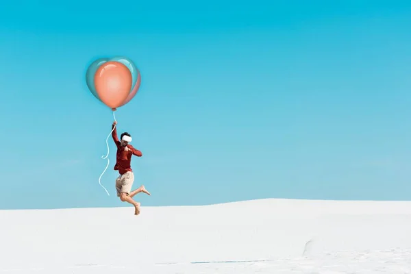 Homme sur la plage de sable vr casque volant sur ballon contre ciel bleu clair — Photo de stock