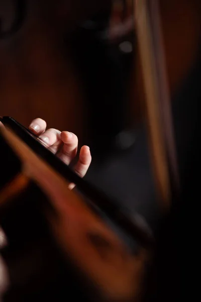 Cropped view of professional musician playing on violin on dark stage — Stock Photo