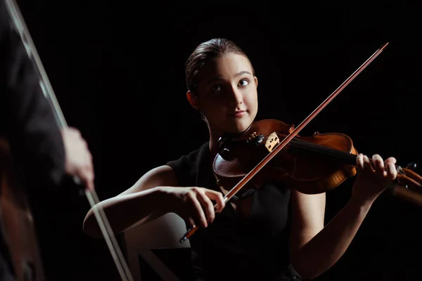 Musiciens professionnels jouant sur violon et contrebasse sur scène sombre — Photo de stock