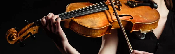Partial view of female musician playing on violin isolated on black, horizontal image — Stock Photo