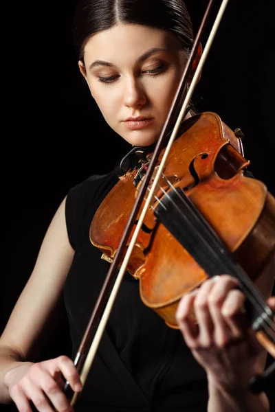 Beautiful professional musician playing symphony on violin isolated on black — Stock Photo