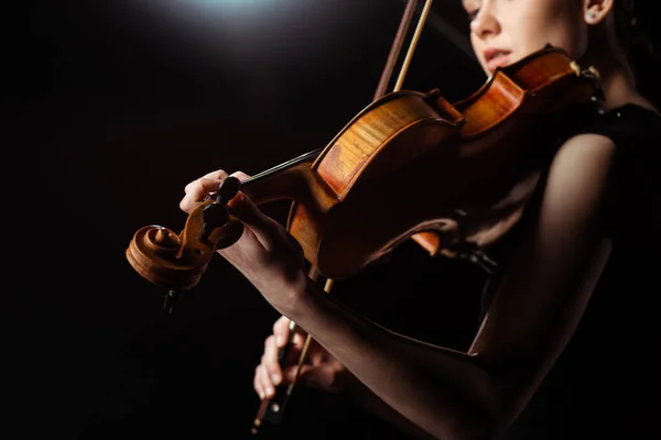 Attractive female musician playing on violin on dark stage — Stock Photo