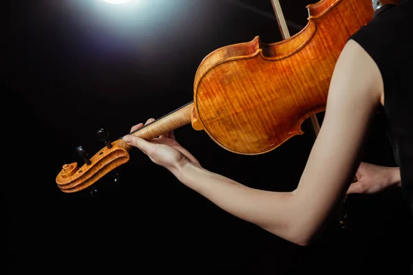 Vista cortada de músico feminino profissional tocando no violino no palco escuro — Fotografia de Stock