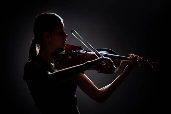 Silueta de músico profesional tocando el violín en el escenario oscuro - foto de stock