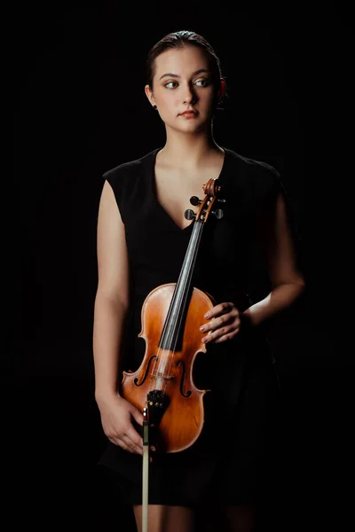 Beau musicien professionnel tenant instrument de musique isolé sur noir — Photo de stock