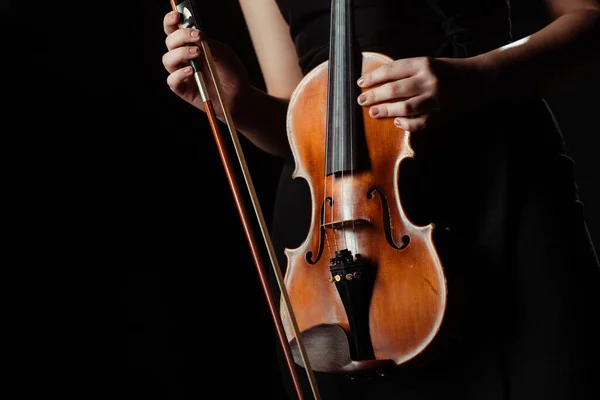 Vue partielle du musicien tenant le violon isolé sur noir — Photo de stock