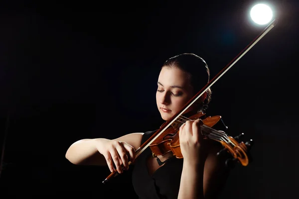 Atraente músico feminino tocando violino no preto com luz traseira — Fotografia de Stock