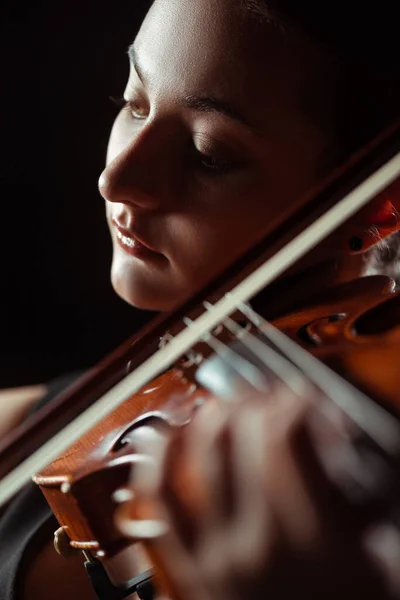 Beau musicien professionnel jouant de la symphonie sur violon isolé sur noir, mise au point sélective — Photo de stock