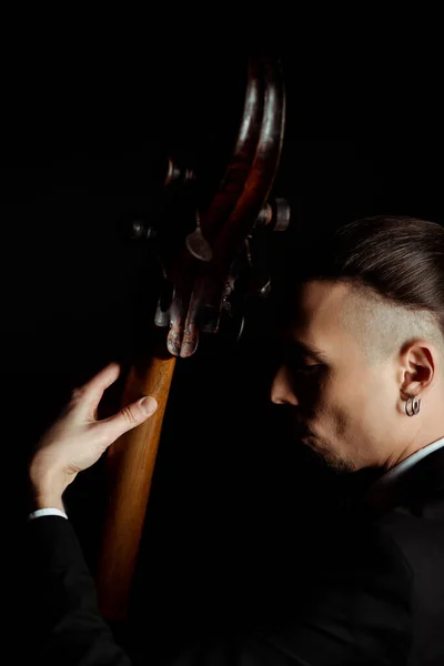 Professional musician playing on musical instrument isolated on black — Stock Photo