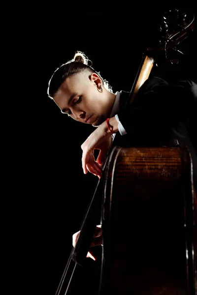 Male professional musician playing on double bass isolated on black — Stock Photo
