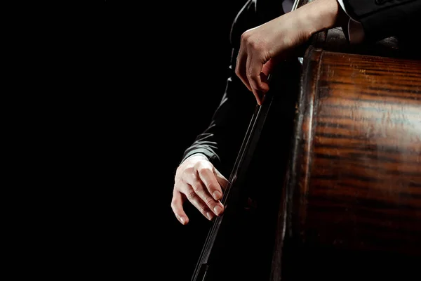 Частковий вид чоловіка професійного музиканта, який грає на контрабасі ізольовано на чорному — стокове фото