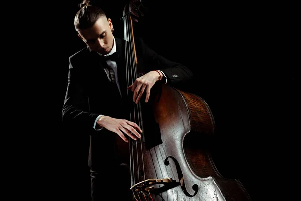 Male musician playing on contrabass isolated on black — Stock Photo