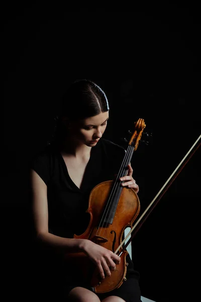 Bela músico feminino segurando violino isolado em preto — Fotografia de Stock