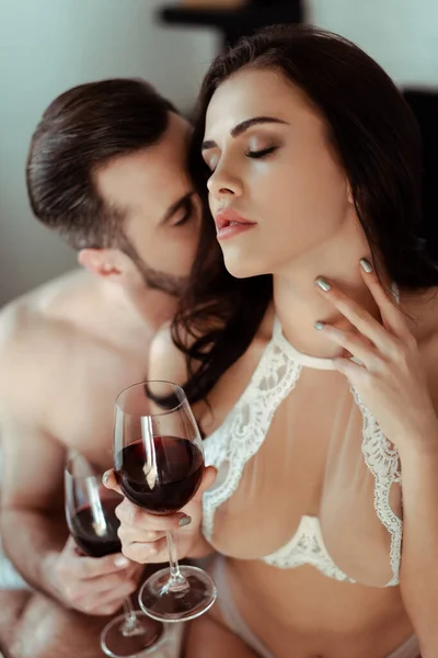 Sexy desvestida pareja bebiendo vino tinto con los ojos cerrados - foto de stock