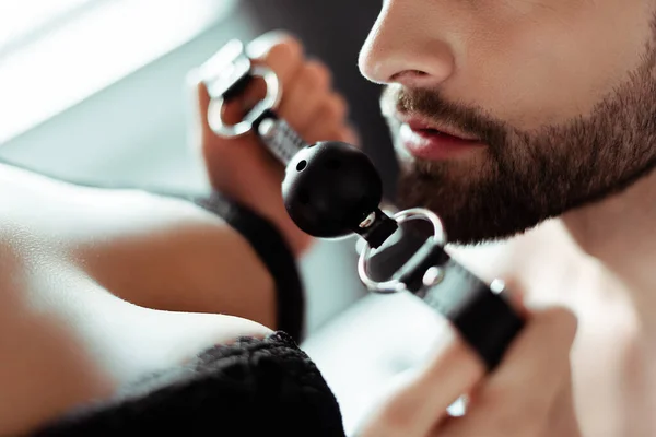 Cropped view of woman with big breast holding gag near male face — Stock Photo