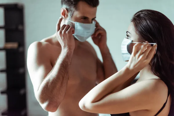 Selective focus of sexy couple in medical masks — Stock Photo
