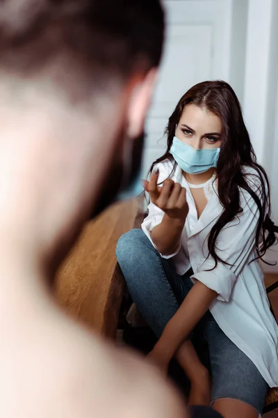 Foyer sélectif de jeune femme sexy dans le masque médical attirer petit ami dans la cuisine — Photo de stock