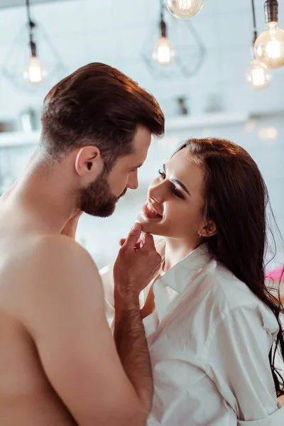 Mulher feliz com namorado sem camisa sexy na cozinha — Fotografia de Stock