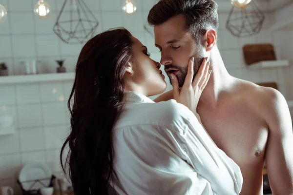 Sexy young passionate couple kissing in kitchen — Stock Photo