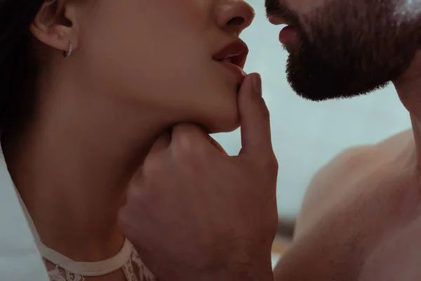 Vista de cerca del hombre tocando los labios de la mujer joven sexy - foto de stock