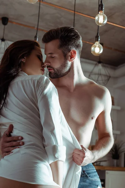 Sexy joven apasionado pareja besos en cocina - foto de stock