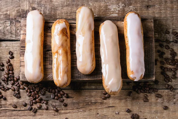 Coffee eclairs over wood — Stock Photo, Image