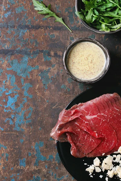 Beef carpaccio with arugula and sauce — Stock Photo, Image