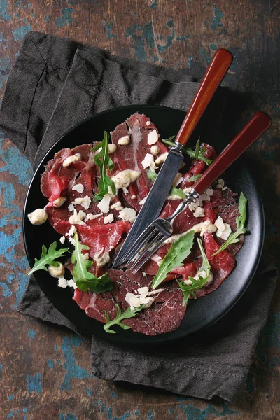 Beef carpaccio with arugula and sauce — Stock Photo, Image