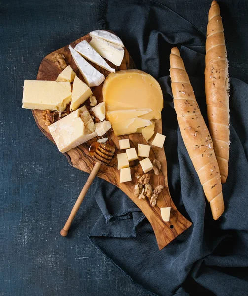 Surtido de queso sobre tabla de madera —  Fotos de Stock