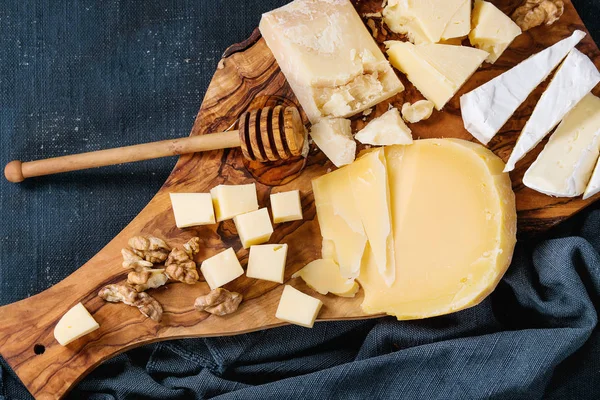 Surtido de queso sobre tabla de madera — Foto de Stock