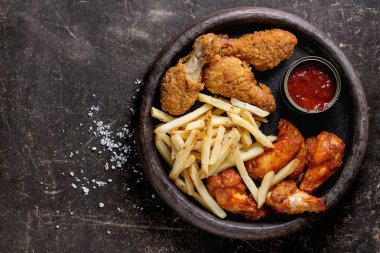 Kızarmış tavuk budu ve patates kızartması.