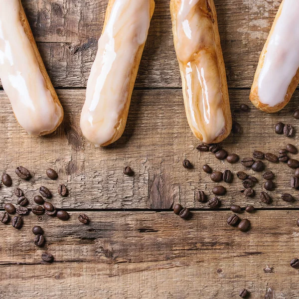 Coffee eclairs over wood — Stock Photo, Image