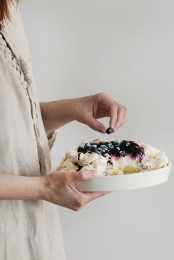 Kadın elinde beze pasta Pavlova