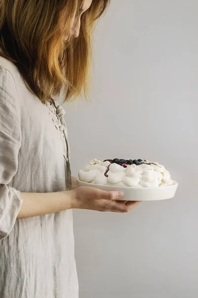 Meringue cake Pavlova in female hands