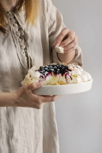 Meringue cake Pavlova in female hands