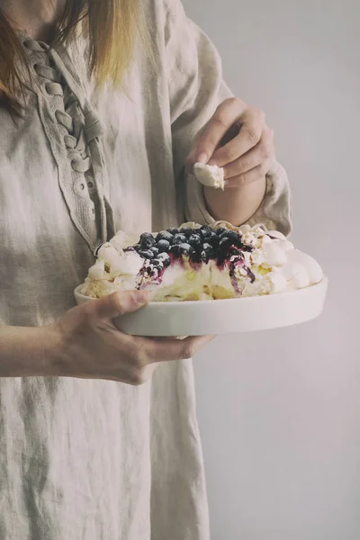 Meringue gâteau Pavlova dans les mains féminines — Photo