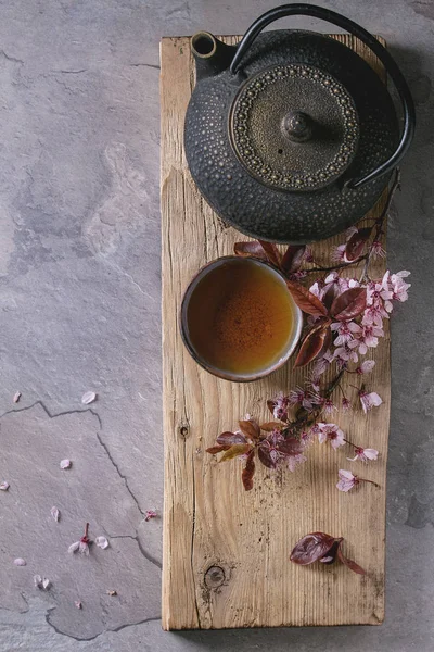Teiera e tazza di tè con ramo di fiori — Foto Stock