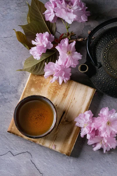 Théière et tasse de thé avec branche de fleur — Photo