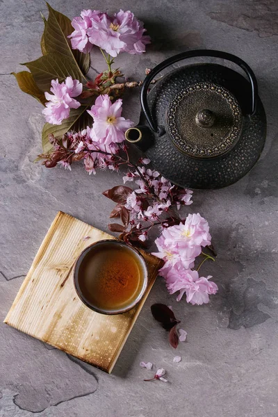 Théière et tasse de thé avec branche de fleur — Photo